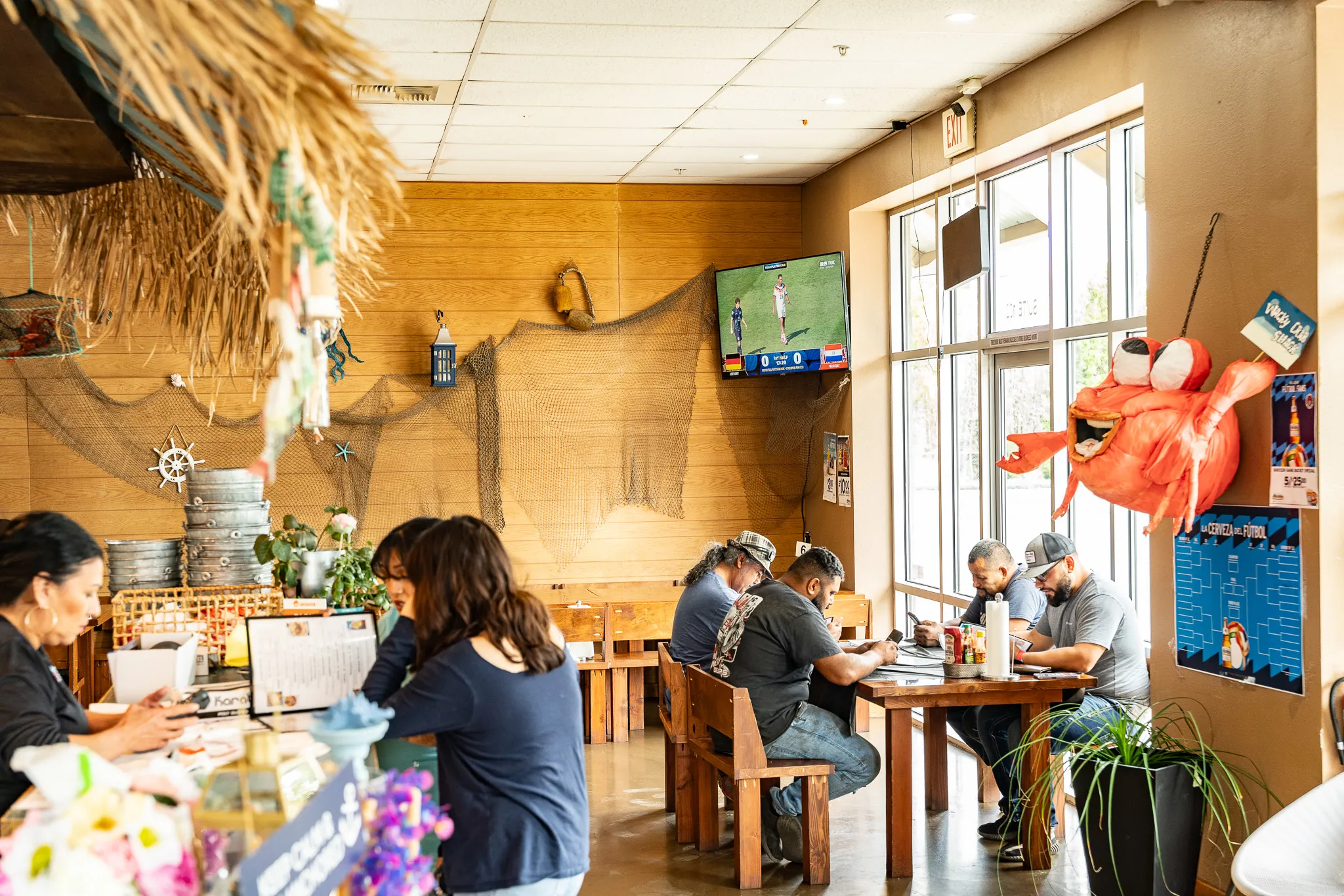 Wooden tables and beach-style decor inside Wacky Crab Shack, ready for a busy dinner service