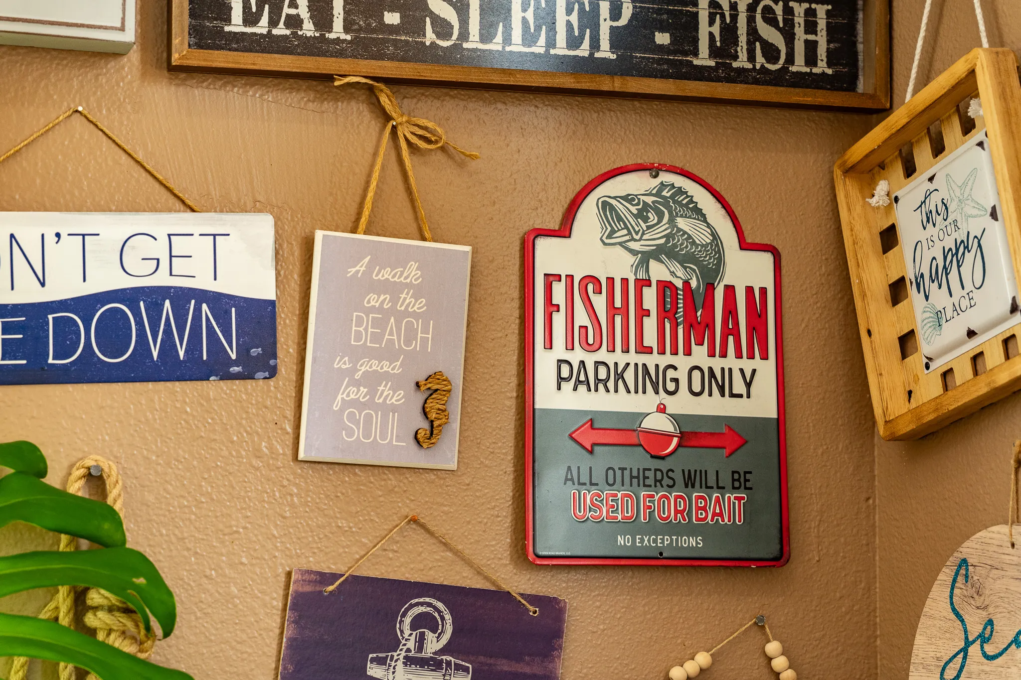 A "Fisherman Parking Only" metal sign and "A Walk on the Beach" décor on the Wacky Crab Shack dining-room wall